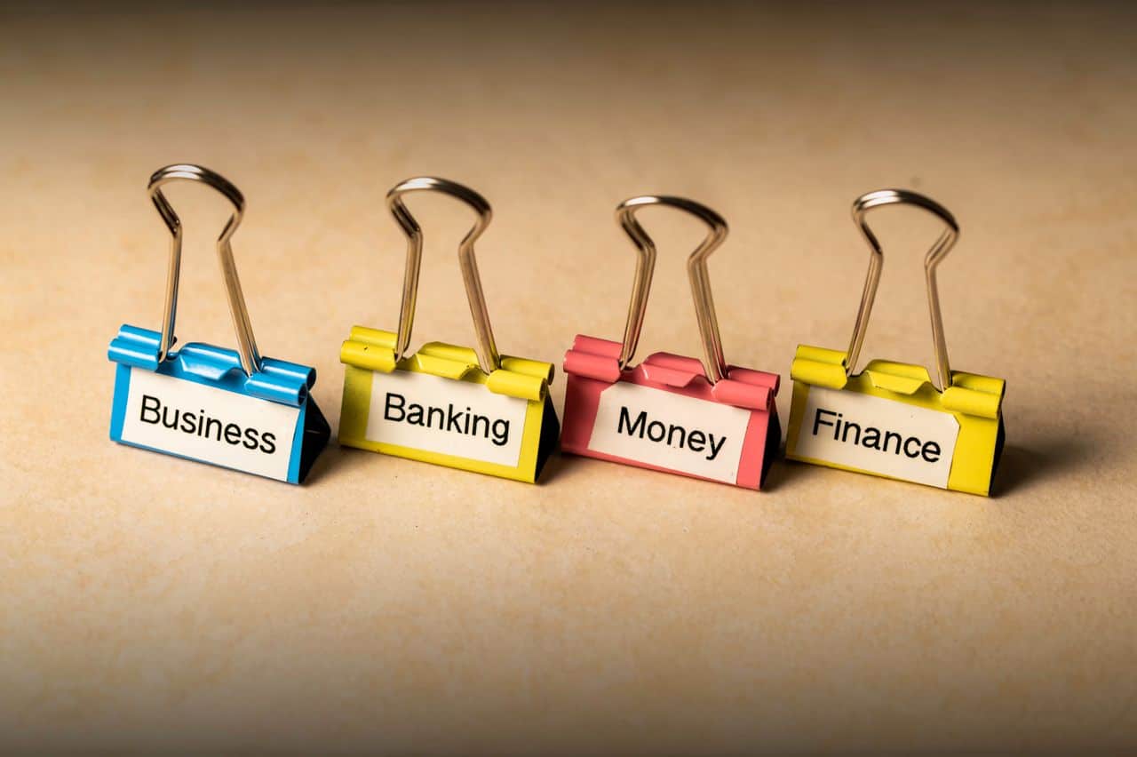 The Art of Drawing Readers In: Your attractive post title goes here Close-up of binder clips with labels for business, banking, money, and finance concepts.