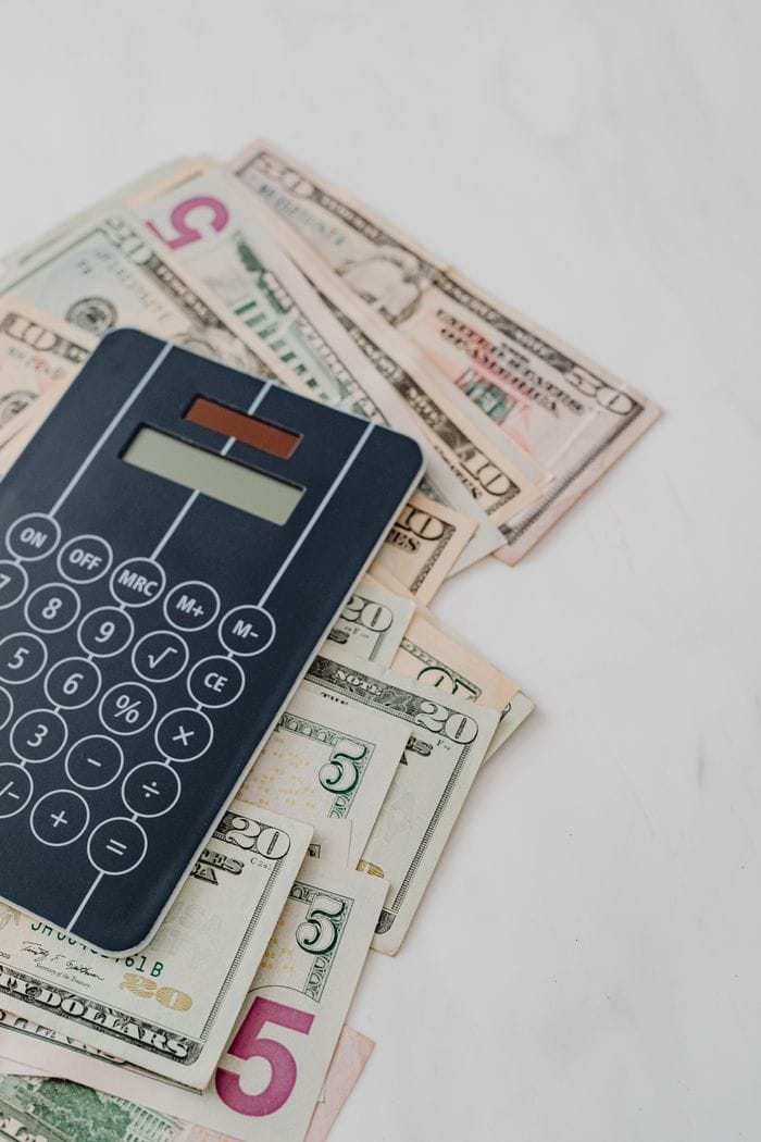 Mastering the First Impression: Your intriguing post title goes here Calculator and US dollar banknotes, symbolizing finance and budgeting.